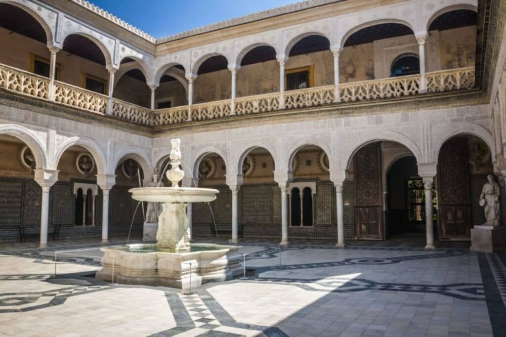 Patio andaluz mudejar con azulejos tradicionales en palacio de Sevilla